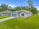 Well-manicured front yard and blue garage door create curb appeal for this modern single-Gathering home at 2404 Hanford Ln, North Port, FL 34288