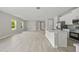 Bright living room with luxury vinyl plank floors, and a modern kitchen with stainless steel appliances at 2404 Hanford Ln, North Port, FL 34288