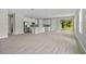 Bright living room with luxury vinyl plank floors, and a modern kitchen with stainless steel appliances at 2404 Hanford Ln, North Port, FL 34288