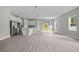 Bright living room with luxury vinyl plank floors, and a modern kitchen with stainless steel appliances at 2404 Hanford Ln, North Port, FL 34288