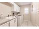 Bright laundry room with white cabinets and a utility sink at 2868 Coral Way, Punta Gorda, FL 33950