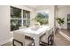 Dining room featuring a modern white table, wood floors, and views of landscaped yard at 956 Harbor Town Dr, Venice, FL 34292