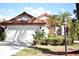 Charming home showcasing a red tile roof, two-car garage, and tropical landscaping at 956 Harbor Town Dr, Venice, FL 34292