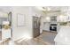 Modern kitchen boasts stainless steel appliances, white cabinetry, stone countertops, and stylish backsplash at 956 Harbor Town Dr, Venice, FL 34292