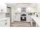 Bright kitchen featuring stainless steel appliances, white cabinets, light backsplash and wood floors at 956 Harbor Town Dr, Venice, FL 34292