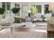 Open-concept living space with stylish seating, decorative plants, and abundant natural light at 956 Harbor Town Dr, Venice, FL 34292