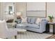 Comfortable living room with a plush blue sofa and view into a bright bedroom at 956 Harbor Town Dr, Venice, FL 34292