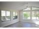 Bright sunroom with walls of windows, hardwood floors, and a vaulted ceiling at 956 Harbor Town Dr, Venice, FL 34292