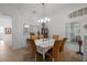 Bright dining room featuring a square table, chandelier, and large windows at 25072 Purple Emperor Way, Punta Gorda, FL 33955