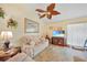 Living room featuring a sofa, armchairs, and a ceiling fan at 18404 Lake Worth Blvd, Port Charlotte, FL 33948