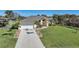 Single-story home with a long driveway, landscaped lawn, and attached garage at 18404 Lake Worth Blvd, Port Charlotte, FL 33948
