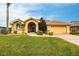 Charming home featuring a well-manicured lawn, arched entryway, and attached two-car garage at 1215 Via Tripoli, Punta Gorda, FL 33950