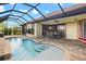 Inviting screened pool and patio with seating area, steps, and a spa at 1736 Suzi St, Punta Gorda, FL 33950