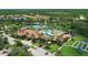 Aerial view of the pool and tennis courts within the Cypress Falls community surrounded by ponds and trees at 2765 Arugula Dr, North Port, FL 34289