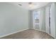 Bedroom featuring wood-look flooring, window with blinds and sheer white curtains at 2765 Arugula Dr, North Port, FL 34289