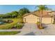 Charming home exterior with a two-car garage, landscaping, and a pond in the back at 2765 Arugula Dr, North Port, FL 34289