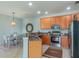 Kitchen and dining area featuring wood cabinets, stainless steel appliances, and a granite countertop at 2765 Arugula Dr, North Port, FL 34289