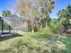 Spacious backyard featuring mature trees and screened-in pool at 3316 Kacher Rd, North Port, FL 34288