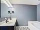 Bathroom featuring a vanity with modern fixtures, a large mirror, and a tiled bathtub with black and white patterned tile floors at 3316 Kacher Rd, North Port, FL 34288