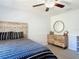 Cozy bedroom with ceiling fan, dresser, round mirror and decorative headboard at 3316 Kacher Rd, North Port, FL 34288