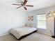 Bedroom featuring a cozy bed, a ceiling fan, a Florida flag wall decor, and a modern standing lamp at 3316 Kacher Rd, North Port, FL 34288