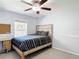 Light bedroom featuring a decorative carved wood bed frame, ceiling fan, and bright natural light at 3316 Kacher Rd, North Port, FL 34288