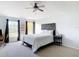 Bedroom with carpet flooring, two windows with curtains, ceiling fan, and decorative headboard with white bedding at 3316 Kacher Rd, North Port, FL 34288