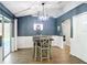 Inviting dining room with modern light fixture, wainscoting, and view of backyard pool at 3316 Kacher Rd, North Port, FL 34288