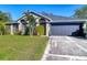 Well-maintained single-story home with a manicured lawn, mature landscaping, and an attached garage at 3316 Kacher Rd, North Port, FL 34288