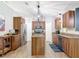 Modern kitchen features stainless steel appliances, wooden cabinets, granite countertops, and a central island at 3316 Kacher Rd, North Port, FL 34288