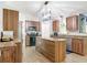 Well-equipped kitchen with wood cabinets, stainless steel appliances, granite countertops and central island at 3316 Kacher Rd, North Port, FL 34288