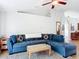 Comfortable living room with a plush blue sectional sofa, ceiling fan, and open access to kitchen at 3316 Kacher Rd, North Port, FL 34288