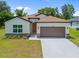 Inviting single-Gathering home with a two-car garage, tidy landscaping, and a charming facade, perfect for suburban living at 3390 Nadasky Ave, North Port, FL 34288