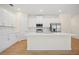 Modern kitchen featuring white cabinetry, stainless steel appliances, and a center island with sleek countertops at 3390 Nadasky Ave, North Port, FL 34288