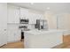 Modern kitchen featuring white cabinetry, stainless steel appliances, and a spacious island with a sink at 3390 Nadasky Ave, North Port, FL 34288