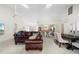 Spacious living room featuring a large brown leather sectional sofa and a view into the kitchen and dining area at 3636 Aruba Ct, Punta Gorda, FL 33950