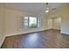 Living room with wood-look floors, white shutters, and access to entryway at 1256 Alton Rd, Port Charlotte, FL 33952