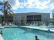 Community pool with ample lounge chairs and beautiful landscaping at 5725 Greenwood Ave # 4, North Port, FL 34287