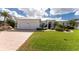 White two-story house with metal roof, two-car garage, and landscaped yard at 1945 Jamaica Way, Punta Gorda, FL 33950
