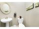 Clean powder room with pedestal sink, toilet, and decorative wall art at 1945 Jamaica Way, Punta Gorda, FL 33950