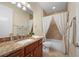 Well-lit bathroom with a granite vanity, toilet, and shower/tub combination with curtain at 2736 Magdalina Dr, Punta Gorda, FL 33950