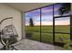Relaxing screened porch with a hanging chair and sunset view at 43050 Greenway Blvd # 614, Punta Gorda, FL 33982