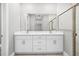 Double vanity bathroom with white cabinets and a frameless shower at 5932 Brickell Dr, North Port, FL 34288