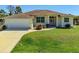 One-story home with attached garage and lush green lawn at 7116 Quigley St, Englewood, FL 34224