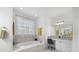 Elegant bathroom with soaking tub, walk-in shower, and double vanity at 7116 Quigley St, Englewood, FL 34224