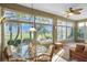 Bright sunroom with view, wicker furniture and glass top table at 24080 Buckingham Way, Punta Gorda, FL 33980