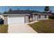 Newly constructed one-story home with a white garage door and grey exterior at 11912 Brookside Ave, Port Charlotte, FL 33981