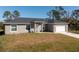 Single-story home with gray siding, a two-car garage, and a landscaped yard at 11964 Coleman Ave, Port Charlotte, FL 33981