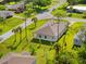 An aerial view of a single-Gathering home with a covered patio, green lawn, and mature palm trees at 1293 Preston St, Port Charlotte, FL 33952