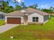 Charming single-story home with a brown garage door and landscaped front yard at 1293 Preston St, Port Charlotte, FL 33952